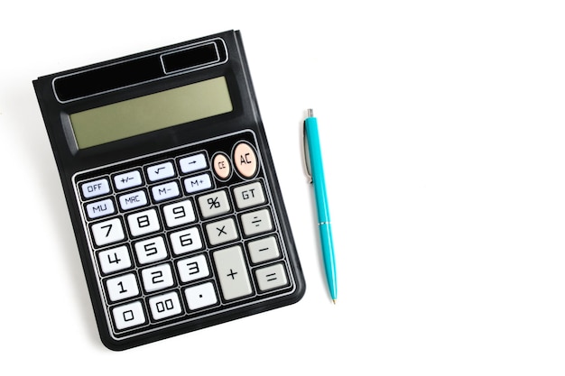 Calculatrice éteinte et un stylo à bille sur fond blanc