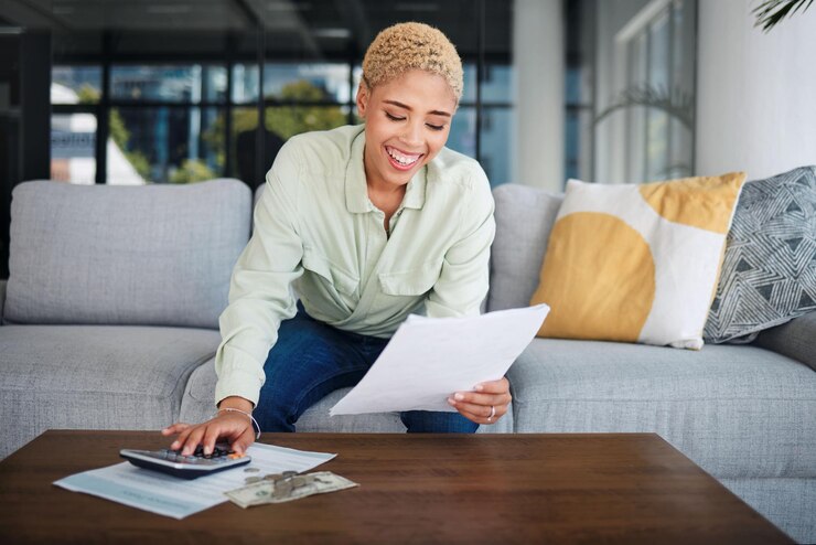 Photo calculatrice de femme et budget sur le canapé pour les documents d'impôts sur le financement de la maison et la gestion des revenus ou des salaires personne africaine heureuse avec de l'argent liquide et de la paperasse pour les économies de bénéfices et les factures ou le paiement