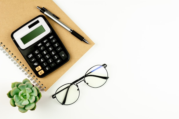 Calculatrice et fournitures de bureau sur tableau blanc.