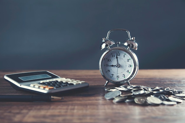 Calculatrice avec horloge et pièces sur table