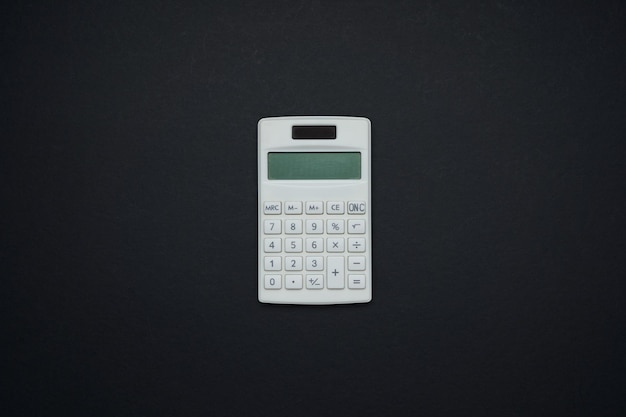 Calculatrice isolée sur fond noir. Mise à plat et vue de dessus avec espace de copie.