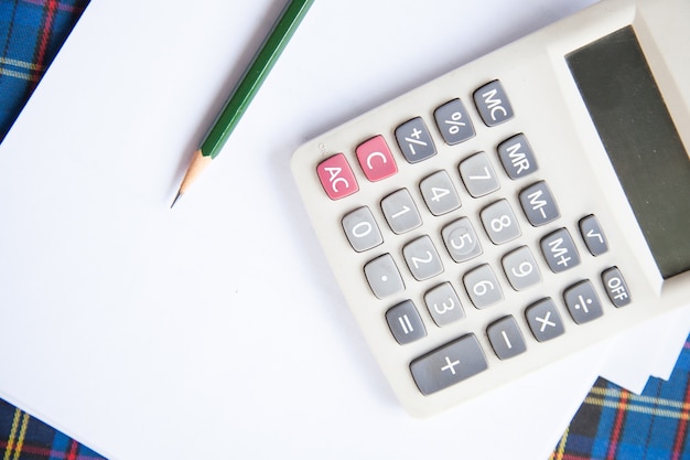 Calculatrice, lunettes, crayon et échelle de rapporteur.