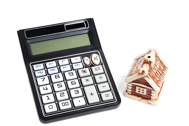 Calculatrice et maison sur fond blanc concept d'achat et de vente d'hypothèque de logement