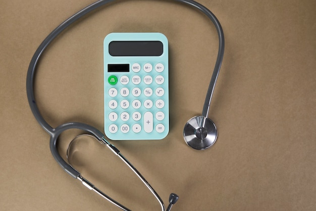 Calculatrice et stéthoscope sur le bureau. concept d'étude de coût