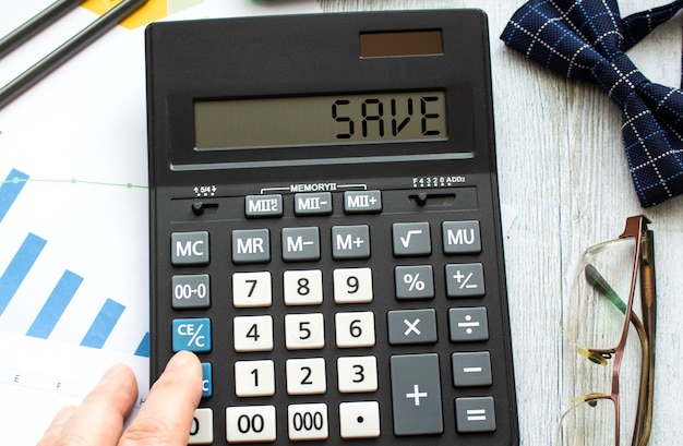 Une calculatrice sur table avec des lunettes et noeud papillon