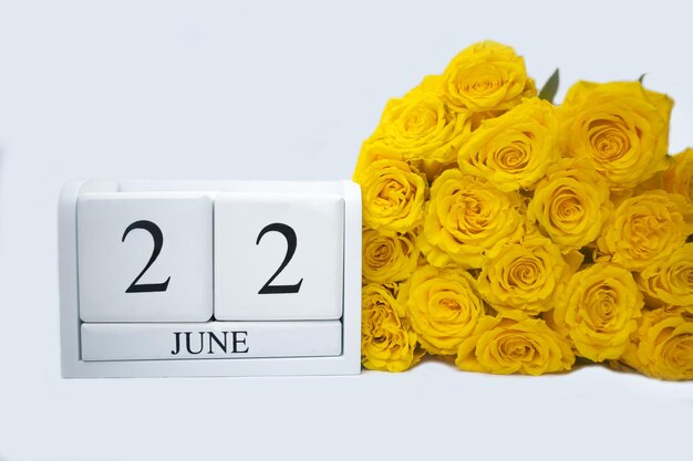 Calendrier blanc en bois 22 juin bouquet de roses jaunes se trouvent à côté