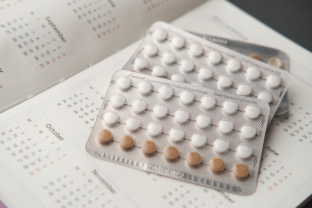 Calendrier et bloc-notes de pilules contraceptives sur la table