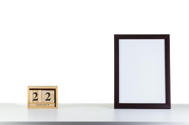 Calendrier en bois 22 janvier avec cadre pour photo sur tableau blanc et arrière-plan