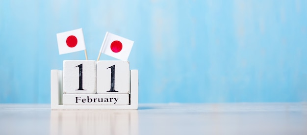 Calendrier en bois du 11 février avec des drapeaux japonais miniatures.