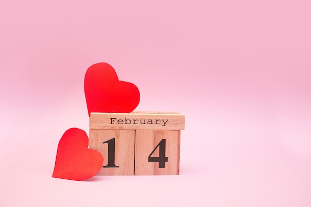 Calendrier en bois sur fond rose avec coeurs rouges. Saint Valentin 14 février