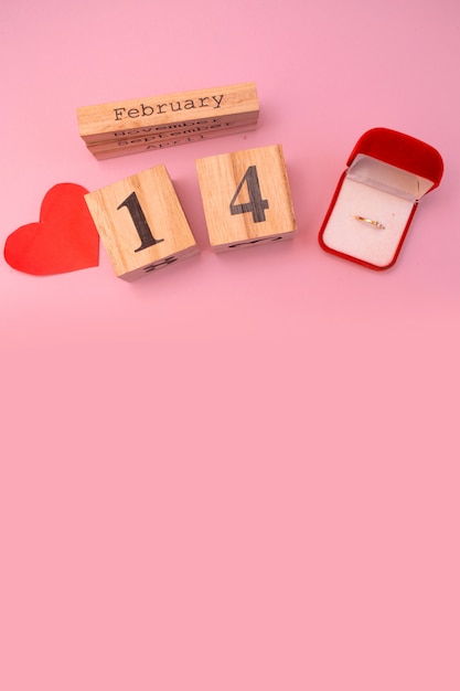 Calendrier en bois sur fond rose avec coeurs rouges. Saint Valentin 14 février