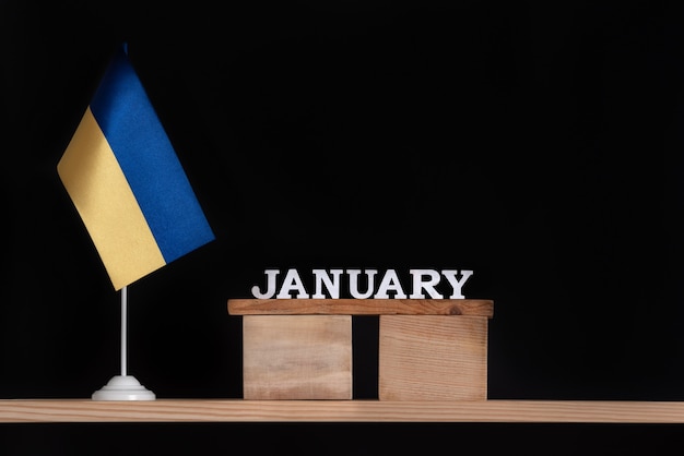 Calendrier en bois de janvier avec drapeau ukrainien sur espace noir. Dates en Ukraine en janvier.