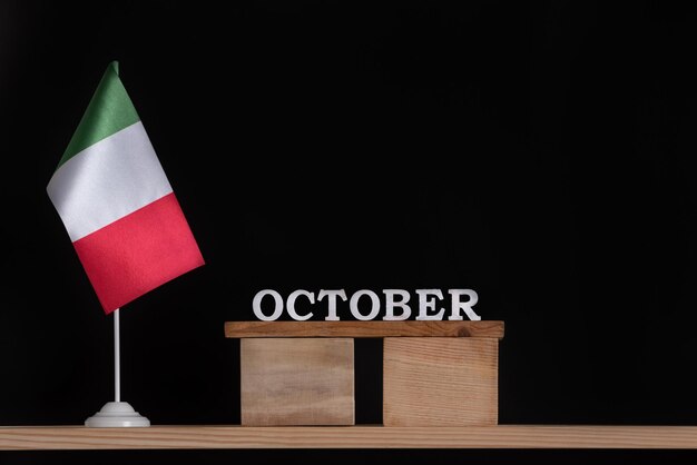 Calendrier en bois d'octobre avec drapeau italien sur fond noir Dates en Italie en octobre