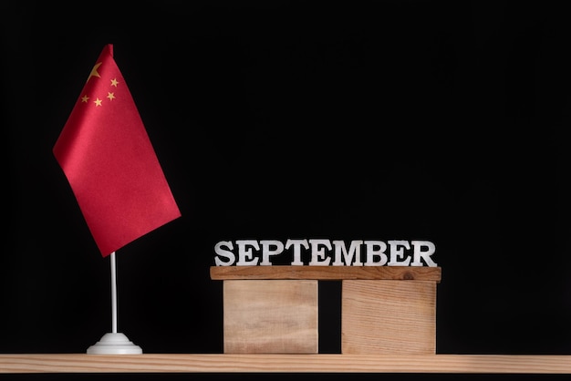 Calendrier en bois de septembre avec drapeau chinois sur fond noir Fêtes de la Chine en septembre