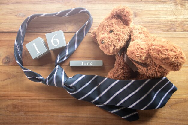 Photo calendrier en bois vintage pour le 16 juin avec ours en peluche et cravate bonne inscripti de la fête des pères