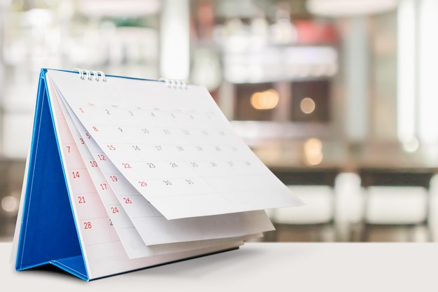 Photo calendrier de bureau sur table avec rendez-vous d'arrière-plan bokeh flou et concept de réunion d'affaires