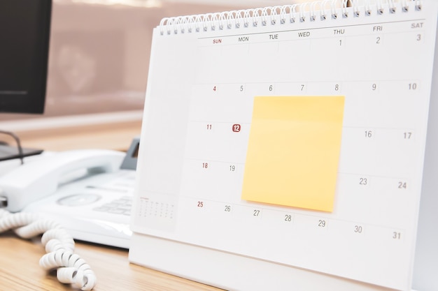 Photo calendrier de bureau vierge avec note papier.