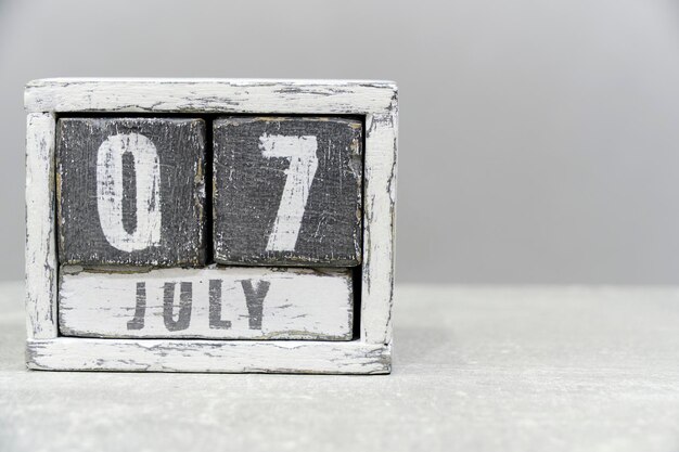 Calendrier du 07 juillet composé de cubes en bois sur fond grisAvec un espace vide pour votre texte