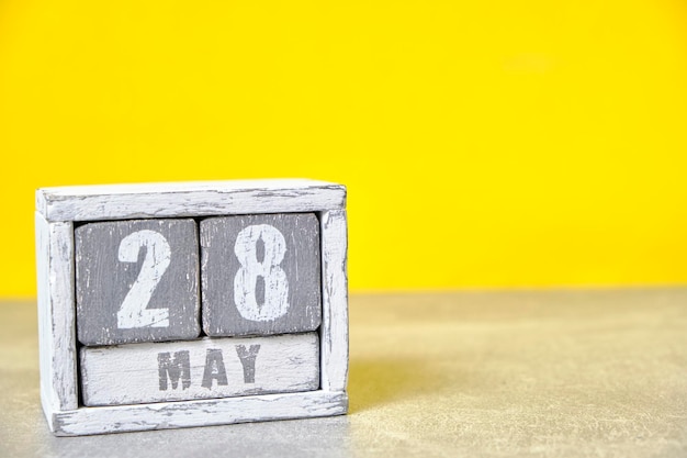 Calendrier du 28 mai en cubes de bois fond jauneAvec un espace vide pour votre texte