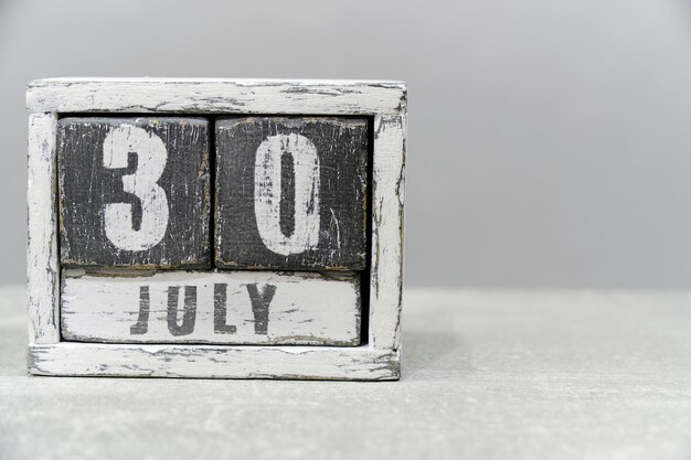 Calendrier du 30 juillet composé de cubes en bois sur fond grisAvec un espace vide pour votre texte