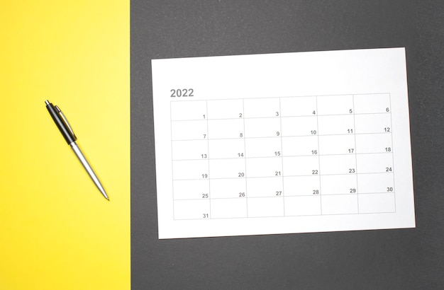 Calendrier du mois calendaire pour prendre rendez-vous ou gérer le calendrier chaque jour et stylo sur fond jaune pour planifier le travail et le concept de voyage.