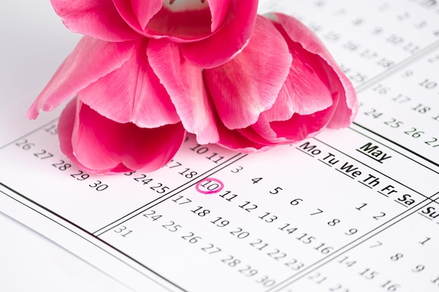 Photo calendrier de la fête des mères avec une date marquée sur un fond de fleurs roses un rappel de la fête