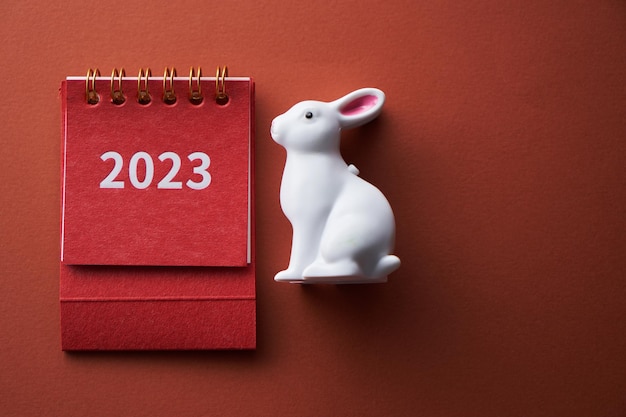 Calendrier sur fond de couleur avec toy rabbit2023 année de lapin