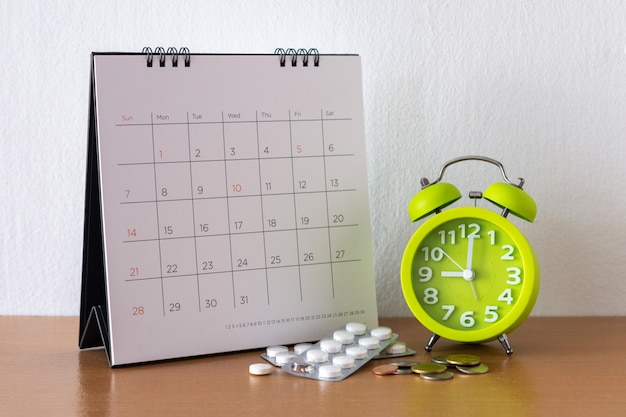 Calendrier et médicaments sur table.