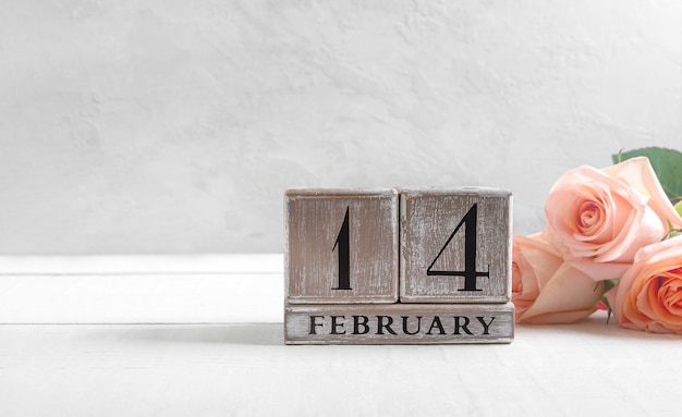 Photo calendrier perpétuel en bois au 14 février, bouquet de roses, saint valentin.