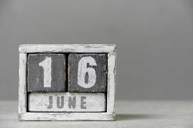 Calendrier pour le 16 juin en cubes de bois sur fond grisAvec un espace vide pour votre texte