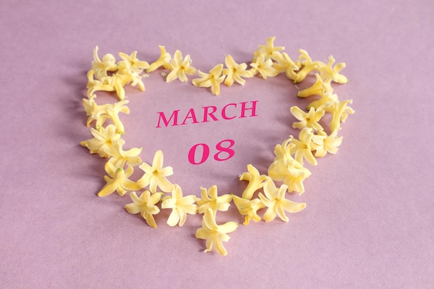 Calendrier pour le 8 mars numéros 08 le nom du mois de mars en anglais dans un coeur fait de fleurs de jacinthe jaune fond pastel vue de dessus