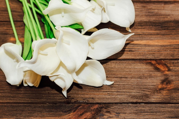 Callas de foamiran sur une table en bois. Fleurs décoratives.