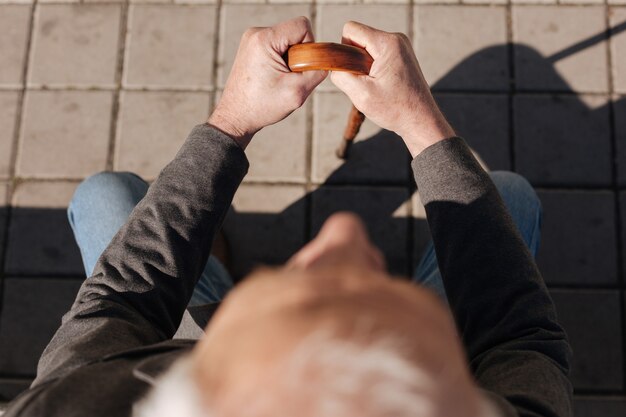 Calme homme rangé fatigué assis sur le banc au repos et au soleil