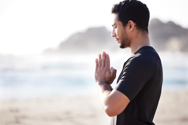 Calmez votre esprit Photo recadrée d'un beau jeune athlète masculin méditant sur la plage