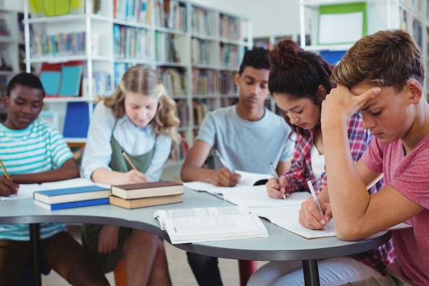 Des camarades de classe attentifs qui étudient en bibliothèque