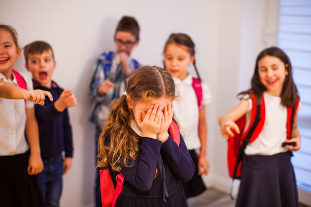 Les camarades de classe désignent le garçon et se moquent de lui