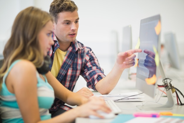 Camarades de classe faisant ensemble dans la salle informatique