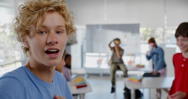 Photo des camarades de classe multiethniques adolescents s'amusant et réalisant une vidéo pour un blog internet en classe