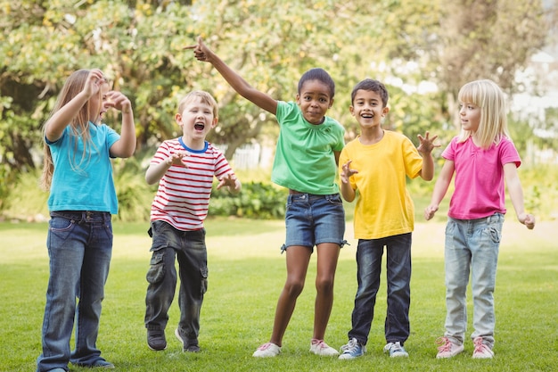 Camarades de classe souriants acclamant et debout dans une rangée