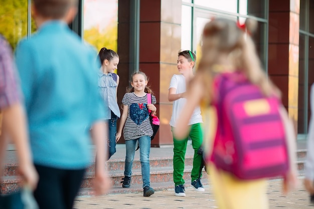 Les camarades de classe vont à l'école. Les élèves se saluent.