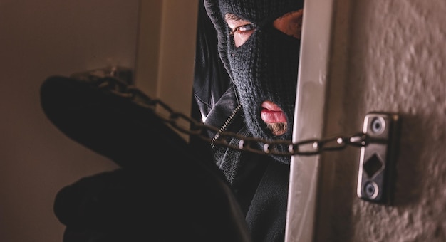 Photo un cambrioleur avec des gants ouvre la porte de l'appartement
