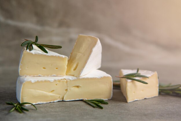 Camembert au fromage ou brie au romarin sur une planche à découper sur fond de pierre de marbre. Espace de copie. Photographie d'atelier.