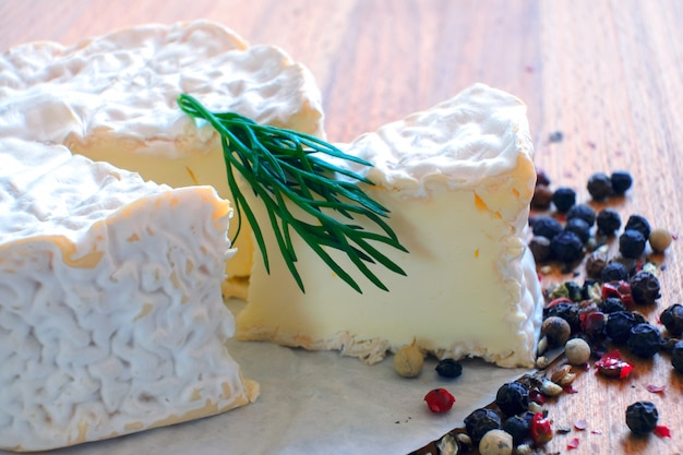 Camembert aux épices et au thym sur une table en bois rustique.