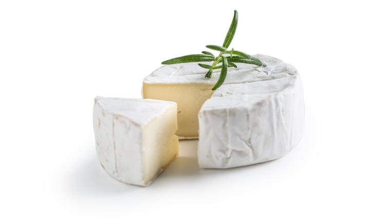 Photo camembert ou brie au romarin isolé sur blanc.