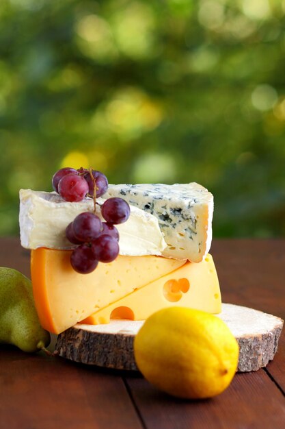 Camembert brie fromage dur et raisins sur support en bois Morceaux de fromage poire et citron