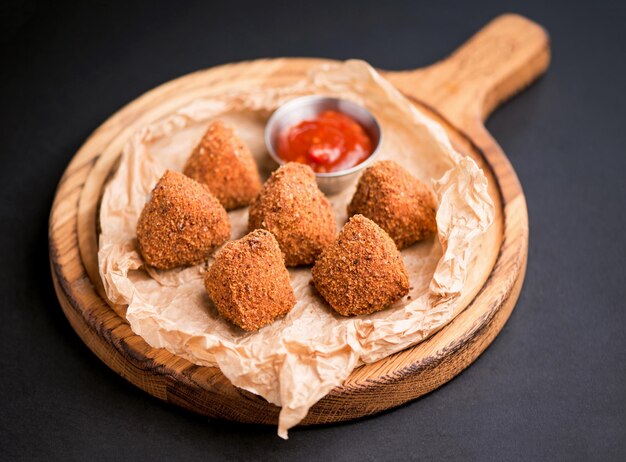 Camembert croustillant frit avec sauce aux canneberges dans une poêle décorative sur fond de bois Close up selecive focus