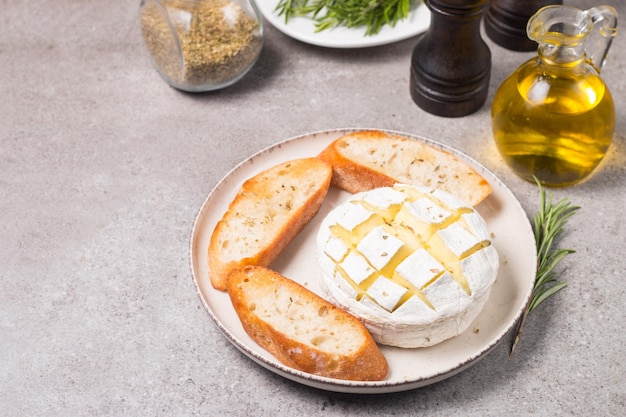 Camembert cuit au four. Brie grillé avec toasts et romarin.