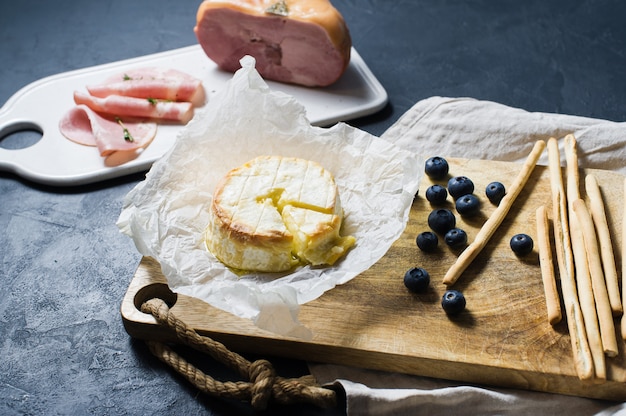 Camembert cuit au four avec myrtilles et jambon.