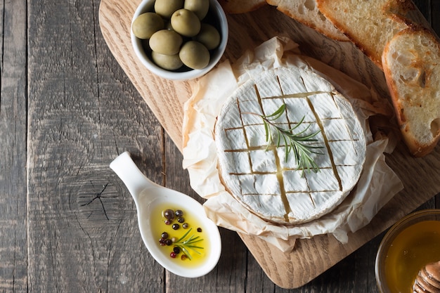 Camembert et fromage brie sur bois avec tomates, laitue et ail. Nourriture italienne. Les produits laitiers.