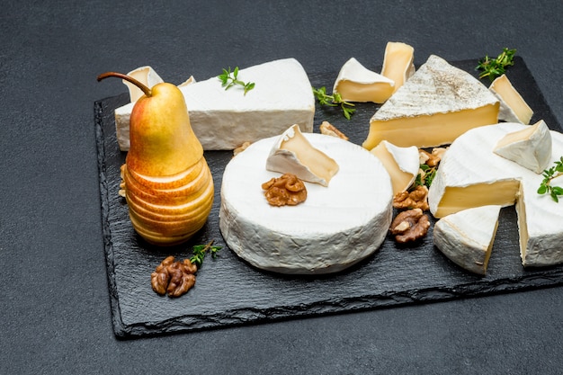 Photo camembert et poire sur planche de pierre